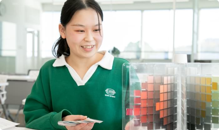 教室でファッションデザインの授業に取り組む女子学生